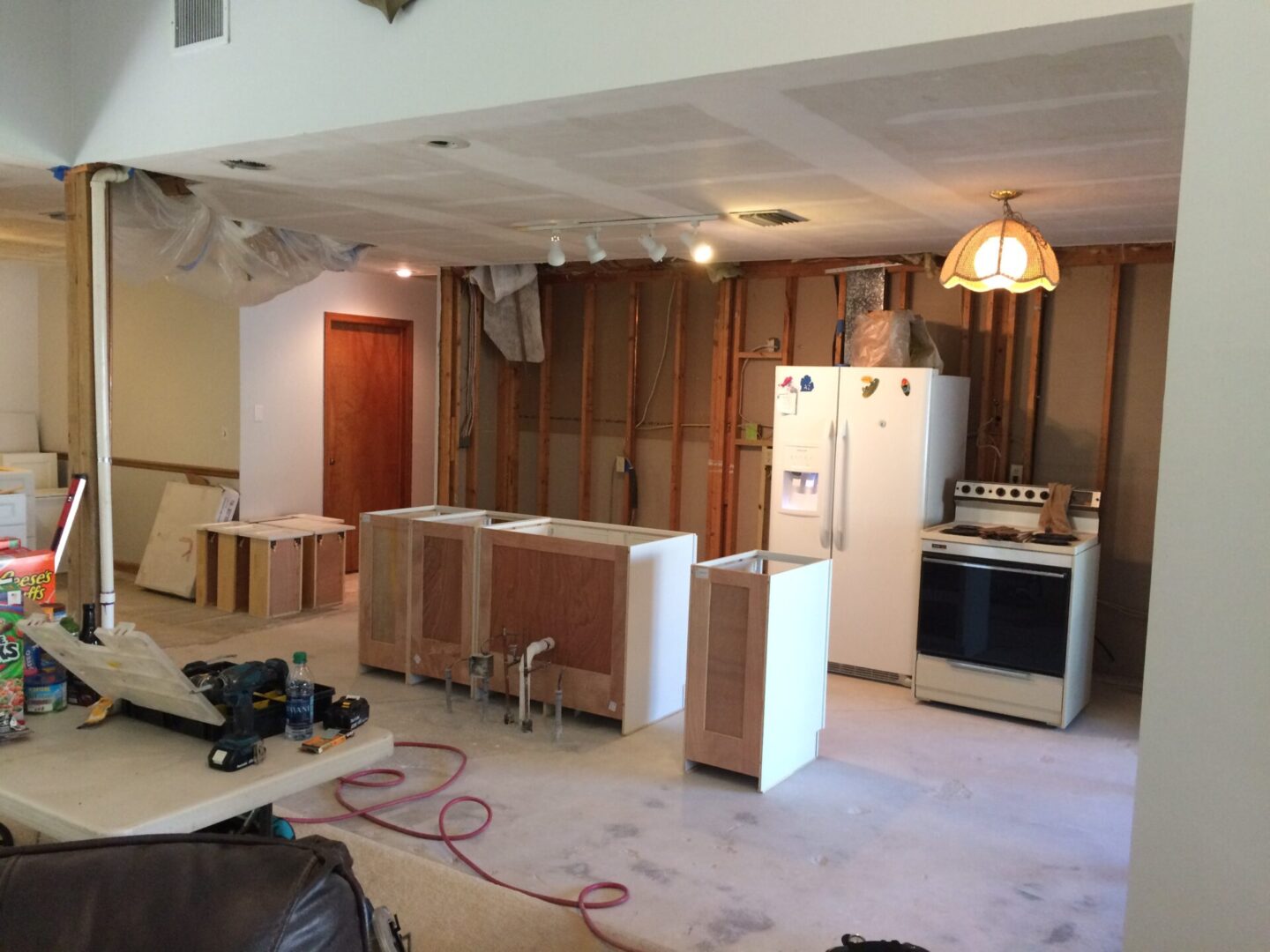 Kitchen under renovation with new cabinets being installed and appliances in place.