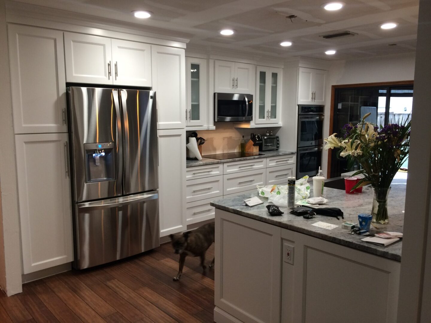 Modern kitchen with stainless steel appliances and white cabinetry.