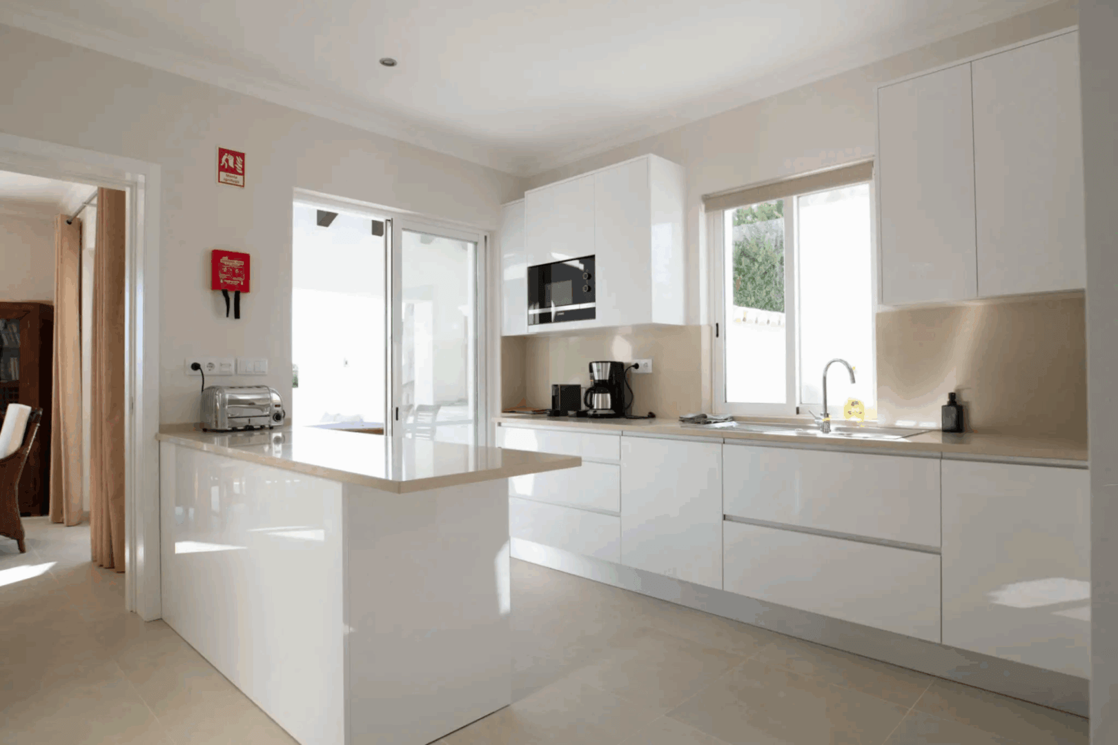 Modern kitchen with white cabinets and natural light.
