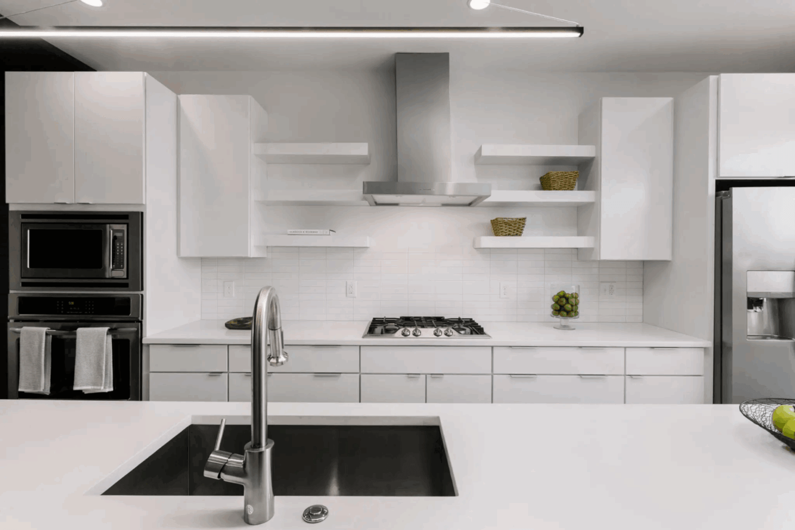 Modern white kitchen with sleek cabinets and stainless steel appliances.