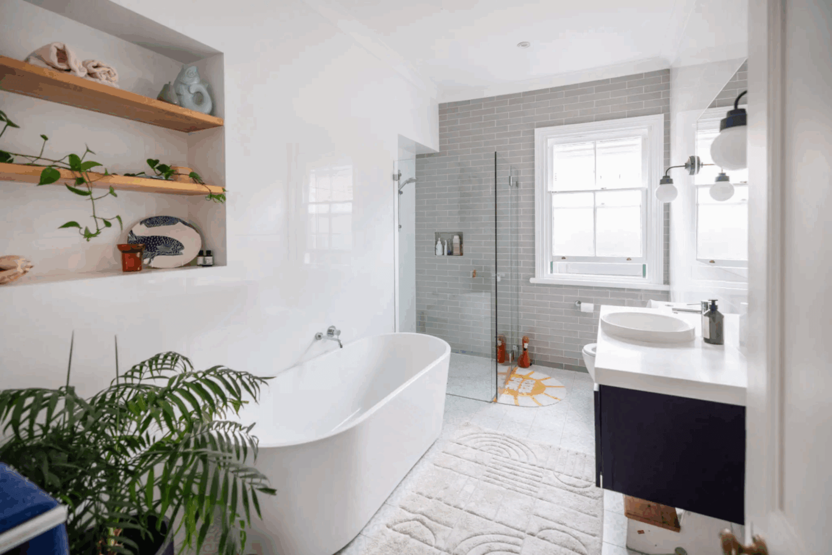 Bright modern bathroom with a freestanding tub and glass shower.